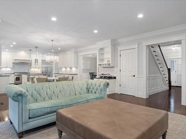 living room featuring crown molding, dark hardwood / wood-style flooring, and a notable chandelier