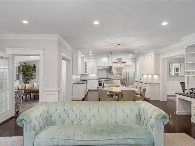 living room with sink, dark hardwood / wood-style floors, and ornamental molding