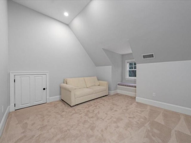 unfurnished room featuring lofted ceiling and light carpet