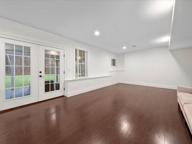 unfurnished living room featuring dark hardwood / wood-style flooring and french doors