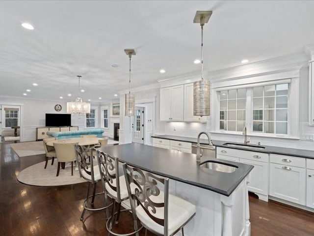 kitchen featuring white cabinetry, sink, and hanging light fixtures