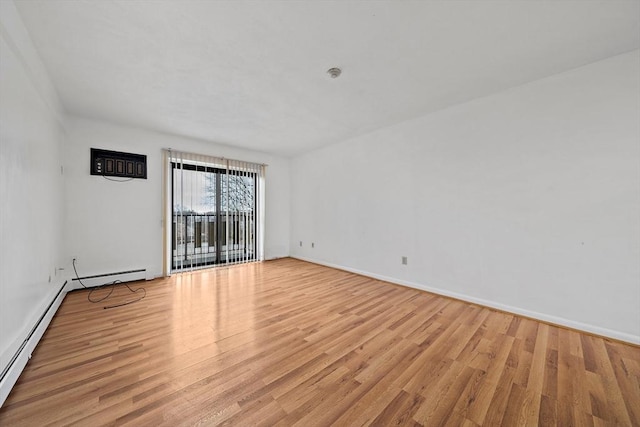 empty room with baseboards, baseboard heating, and light wood-style flooring