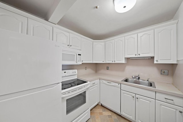 kitchen with stone finish floor, light countertops, white cabinets, white appliances, and a sink