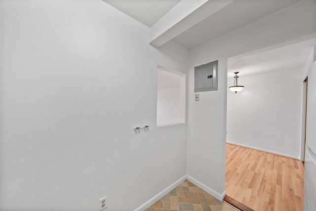 interior space featuring electric panel and baseboards