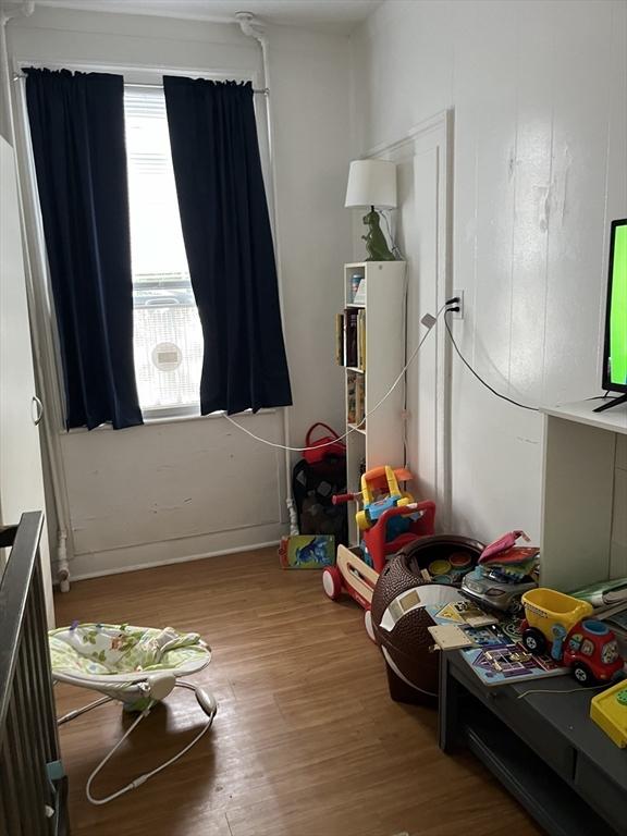 bedroom featuring wood-type flooring and radiator