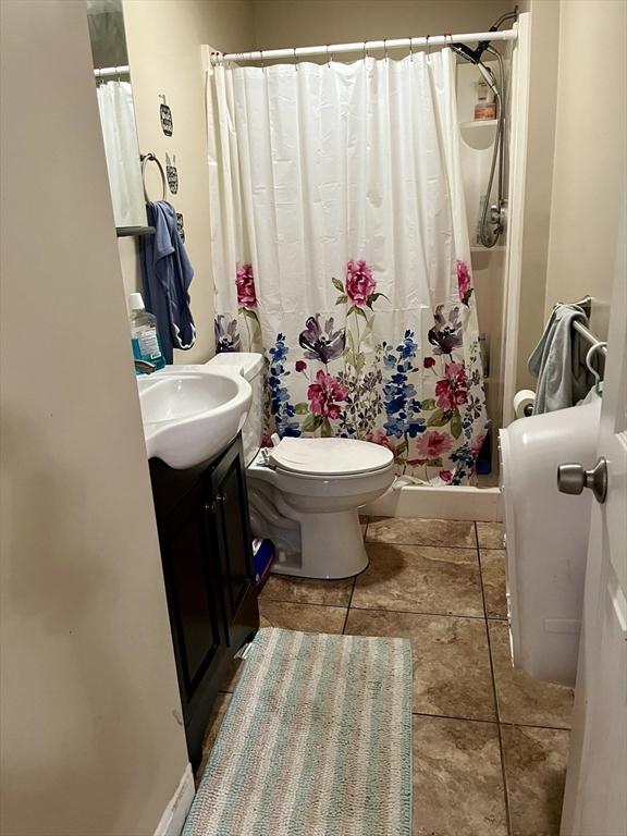 bathroom with walk in shower, vanity, and toilet