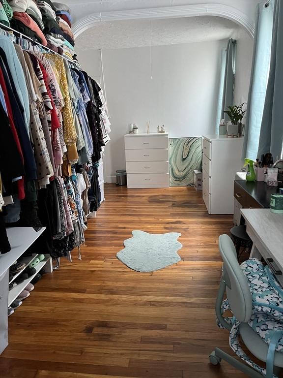 walk in closet with light hardwood / wood-style flooring