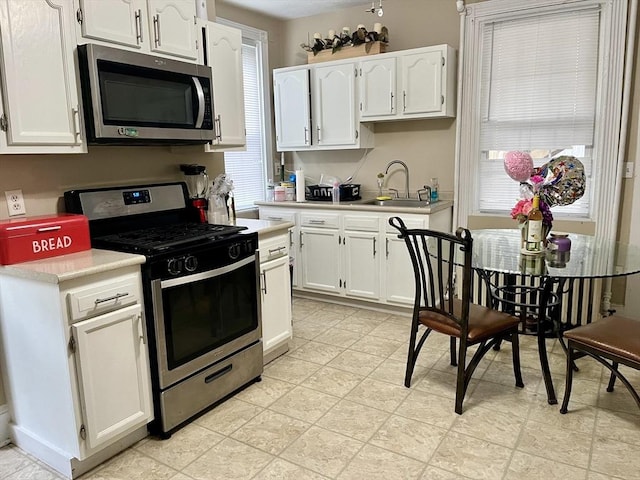 kitchen featuring sink, stainless steel appliances, and white cabinets