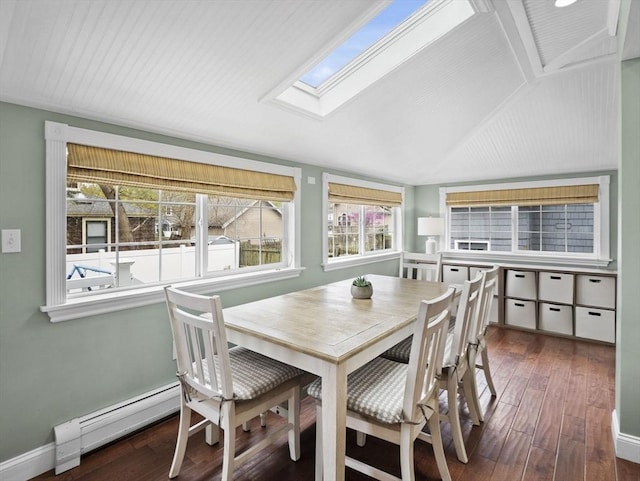 dining room featuring baseboards, lofted ceiling with skylight, baseboard heating, and hardwood / wood-style flooring