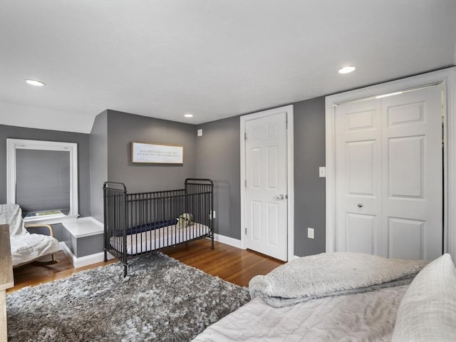 bedroom featuring baseboards, a closet, recessed lighting, and wood finished floors