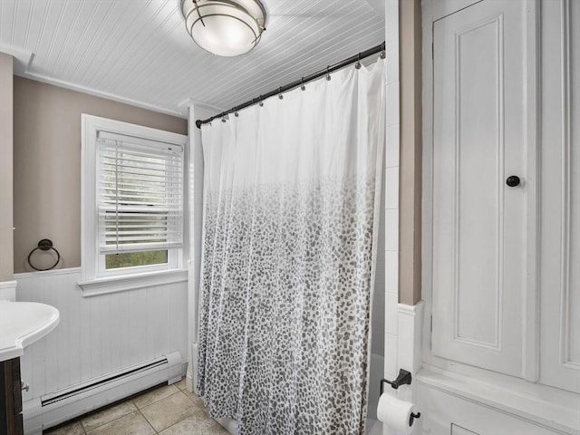 full bath with a shower with curtain, a baseboard radiator, wainscoting, and tile patterned flooring
