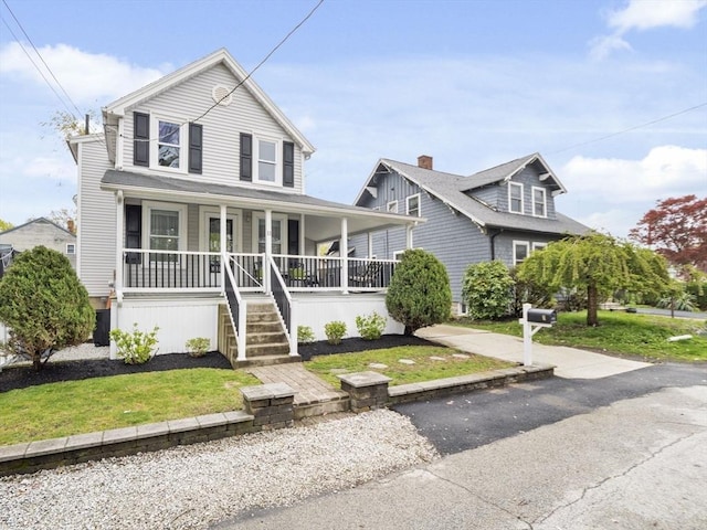 view of front of property featuring covered porch and a front yard