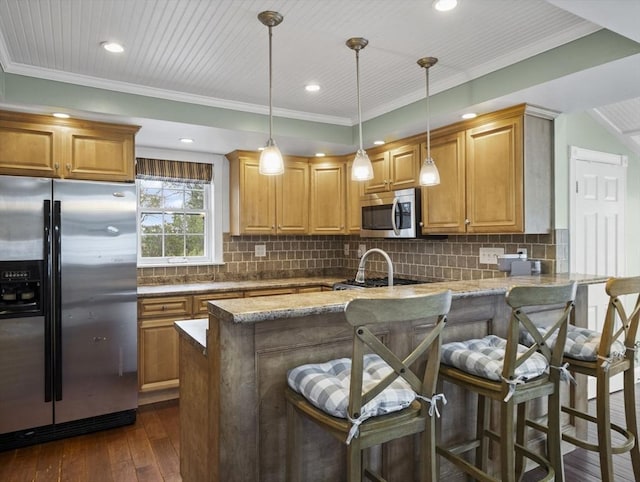 kitchen featuring a peninsula, dark wood finished floors, appliances with stainless steel finishes, and ornamental molding