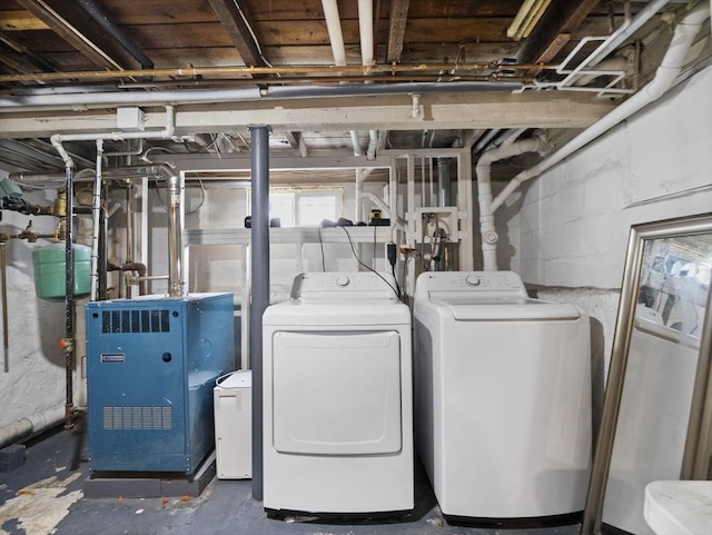 laundry area featuring laundry area, a heating unit, and washing machine and dryer