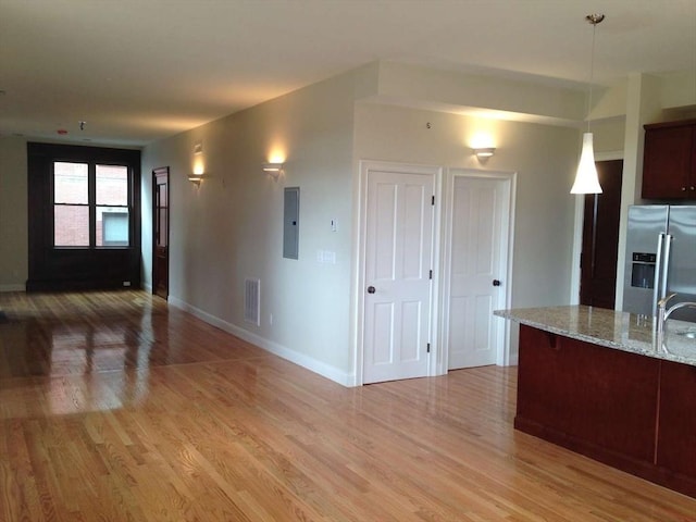 191 Main St Unit 2B, Gloucester, MA 01930 - kitchen with stainless steel fridge, open floor plan, electric panel, and light wood-type flooring