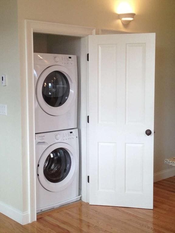 191 Main St Unit 2B, Gloucester, MA 01930 - laundry room with stacked washer / dryer, baseboards, and wood finished floors