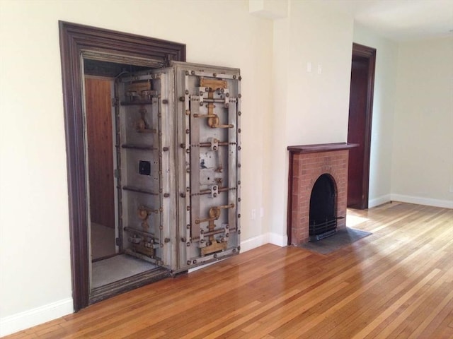 191 Main St Unit 2B, Gloucester, MA 01930 - unfurnished living room featuring wood finished floors, baseboards, and a fireplace