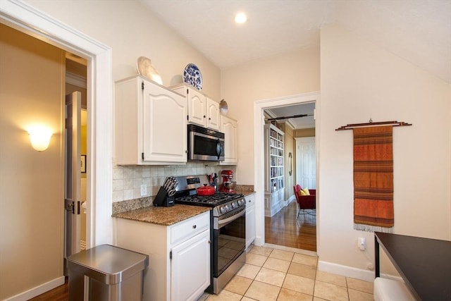 kitchen featuring white cabinets, light tile patterned floors, appliances with stainless steel finishes, and tasteful backsplash