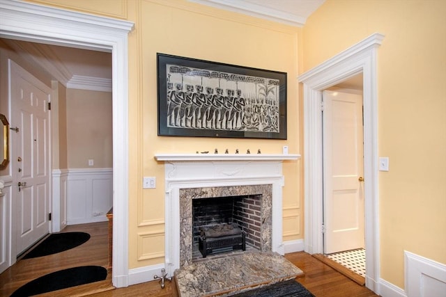 living room with crown molding, hardwood / wood-style flooring, and a premium fireplace