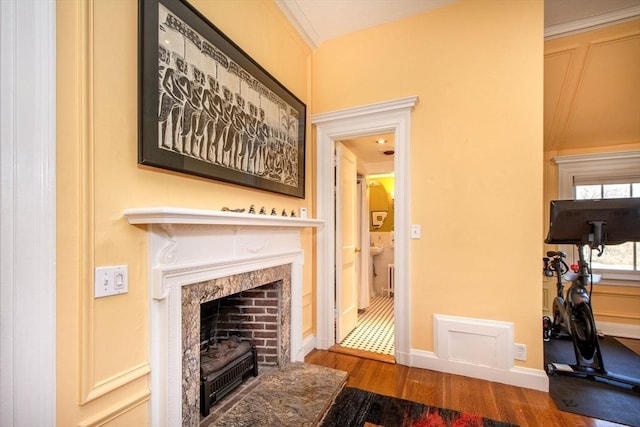 living room with hardwood / wood-style flooring, ornamental molding, and a premium fireplace