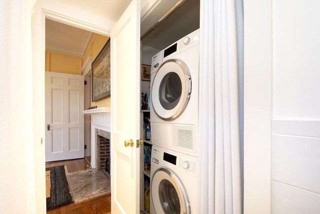 laundry room with dark hardwood / wood-style floors and stacked washing maching and dryer