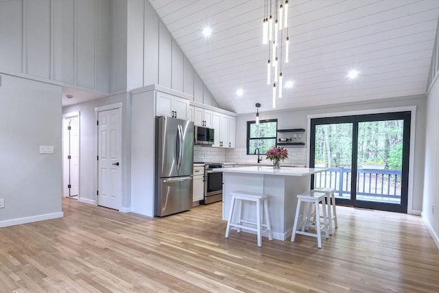 3 Gilbert Ln, Harwich, MA 02646 - kitchen with appliances with stainless steel finishes, light countertops, light wood-type flooring, a kitchen island, and a kitchen bar