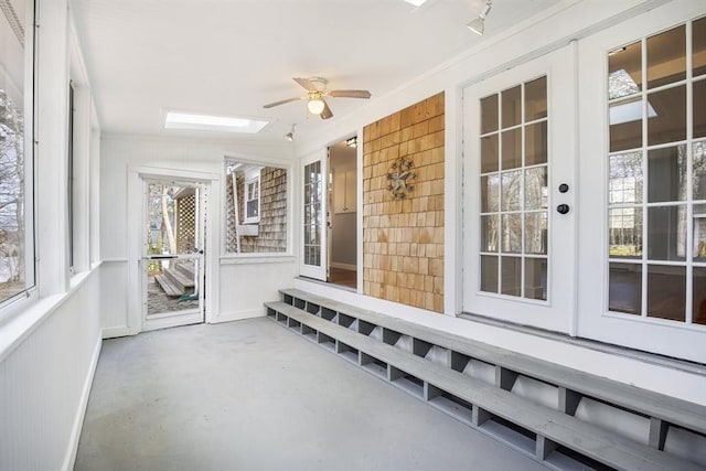 unfurnished sunroom with a skylight and ceiling fan