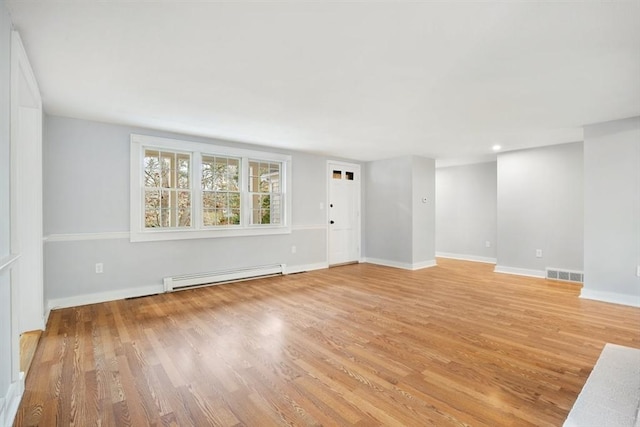 interior space with light wood-type flooring and a baseboard heating unit