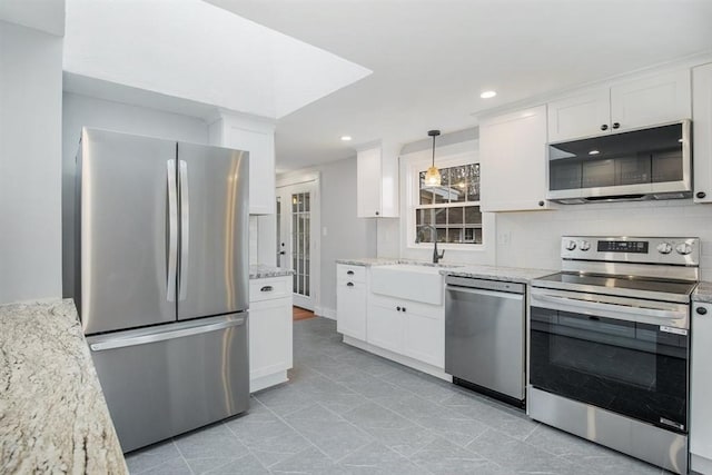 kitchen with white cabinets, pendant lighting, and appliances with stainless steel finishes