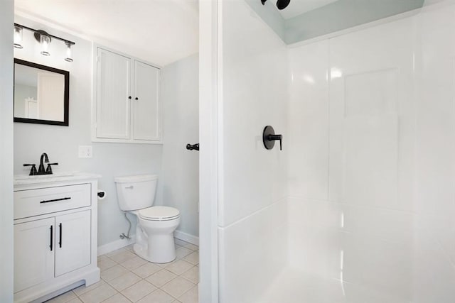 bathroom featuring tile patterned floors, vanity, toilet, and walk in shower