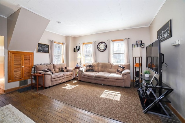 living room with hardwood / wood-style flooring, crown molding, visible vents, and baseboards