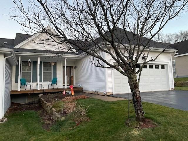 view of front facade with a porch, a garage, and a front yard