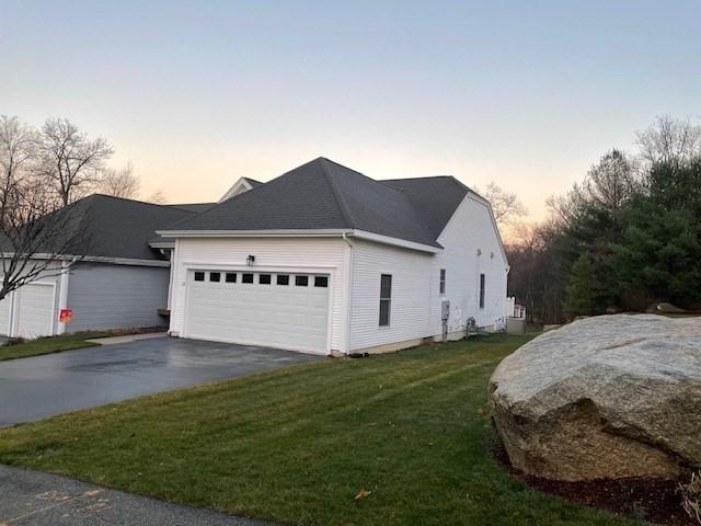 property exterior at dusk featuring a lawn