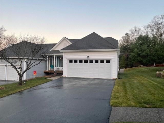 single story home with a garage and a lawn