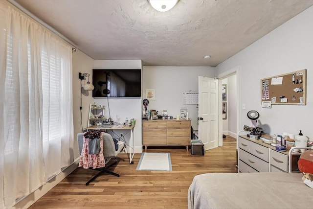 15 Ronan St Unit 3, Boston, MA 02125 - bedroom featuring an office area, light wood-type flooring, a textured ceiling, and baseboards