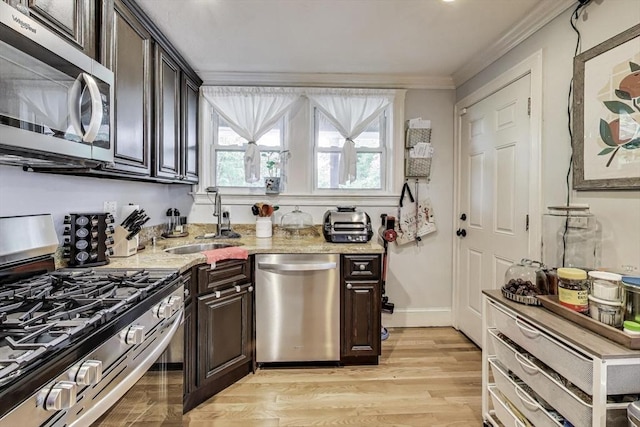 15 Ronan St Unit 3, Boston, MA 02125 - kitchen with stainless steel appliances, crown molding, a sink, dark brown cabinetry, and light wood-style flooring