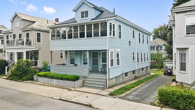 12 Leonard St, Somerville, MA 02144 - view of front facade with a porch, a sunroom, and a shingled roof