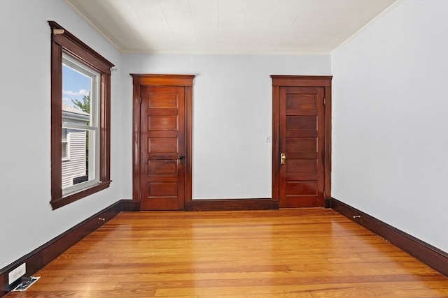 12 Leonard St, Somerville, MA 02144 - empty room with light wood finished floors and crown molding