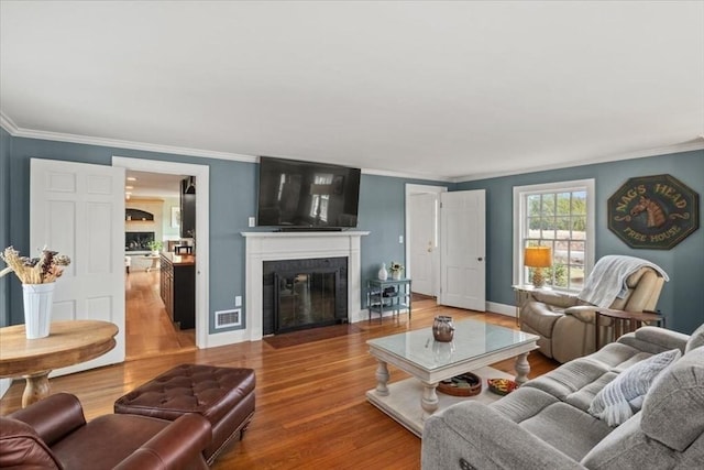 279 Norfolk St, Holliston, MA 01746 - living area with wood finished floors, a fireplace with flush hearth, and crown molding
