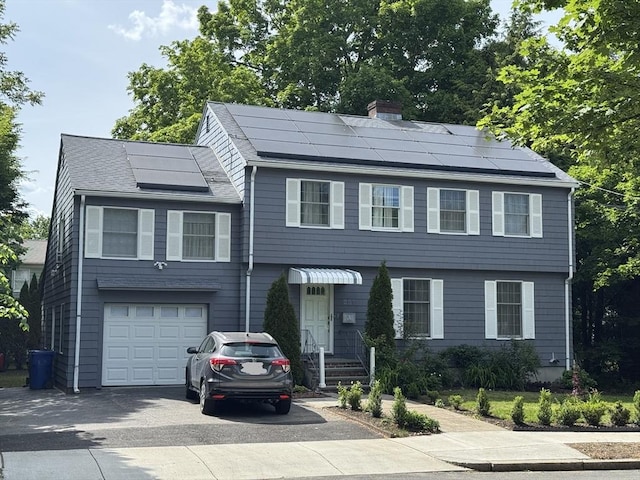 251 Waltham St, Newton, MA 02465 - colonial inspired home featuring concrete driveway, a chimney, a garage, solar panels, and a shingled roof