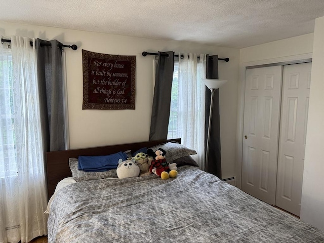 251 Waltham St, Newton, MA 02465 - bedroom featuring a textured ceiling, a closet, and a baseboard heating unit