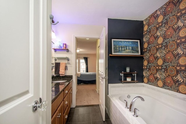 ensuite bathroom with a relaxing tiled tub, tile patterned flooring, connected bathroom, and vanity