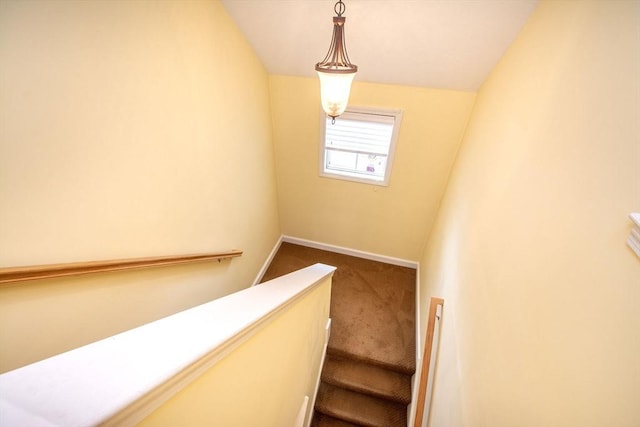 stairway featuring carpet, lofted ceiling, and baseboards