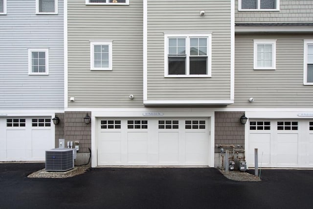 garage with aphalt driveway and central air condition unit