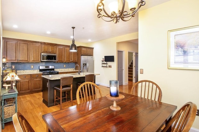 dining room with light wood finished floors, stairway, recessed lighting, and baseboards