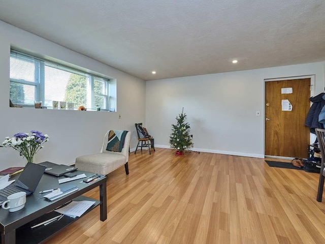 sitting room featuring light hardwood / wood-style flooring and a textured ceiling