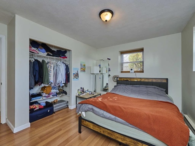 bedroom with a closet, hardwood / wood-style floors, and a textured ceiling