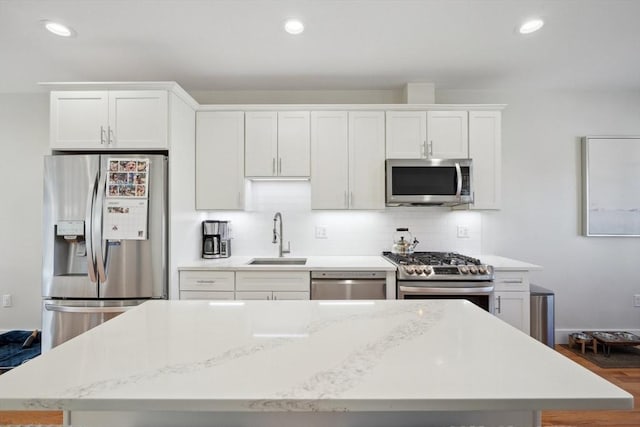 10 Berkley Rd Unit C, Hull, MA 02045 - kitchen featuring stainless steel appliances, a sink, white cabinets, a kitchen island, and backsplash