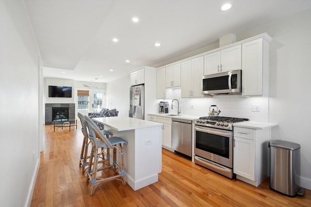 10 Berkley Rd Unit C, Hull, MA 02045 - kitchen with stainless steel appliances, a sink, a kitchen island, light wood-style flooring, and backsplash
