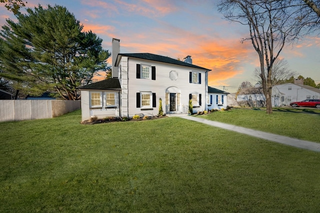 colonial inspired home with a lawn